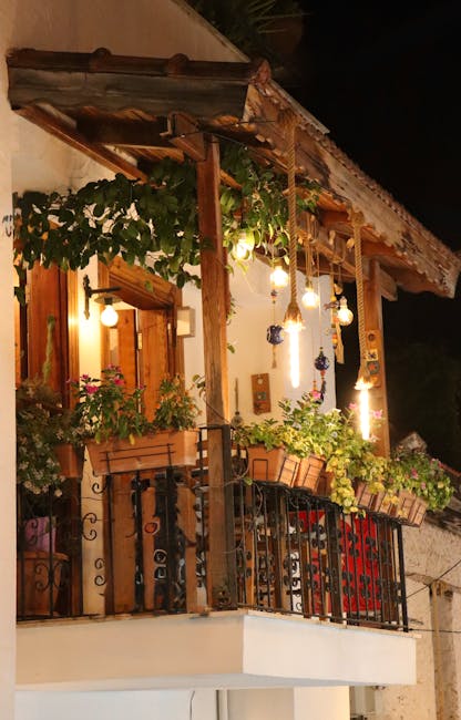 Šiltas apšvietimas ant mažo balkono su sėdėjimo zona vakare