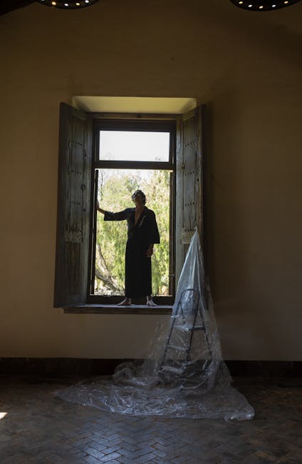 Žmogus atidaro langą mikroventiliacijai rudenį, kambarys apšviestas dienos šviesa