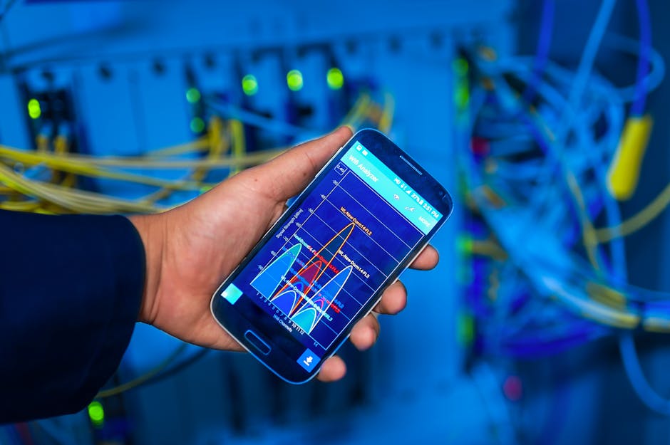 Asmuo vonioje prie sienos matuojantis Wi‑Fi signalą telefonų ekrane