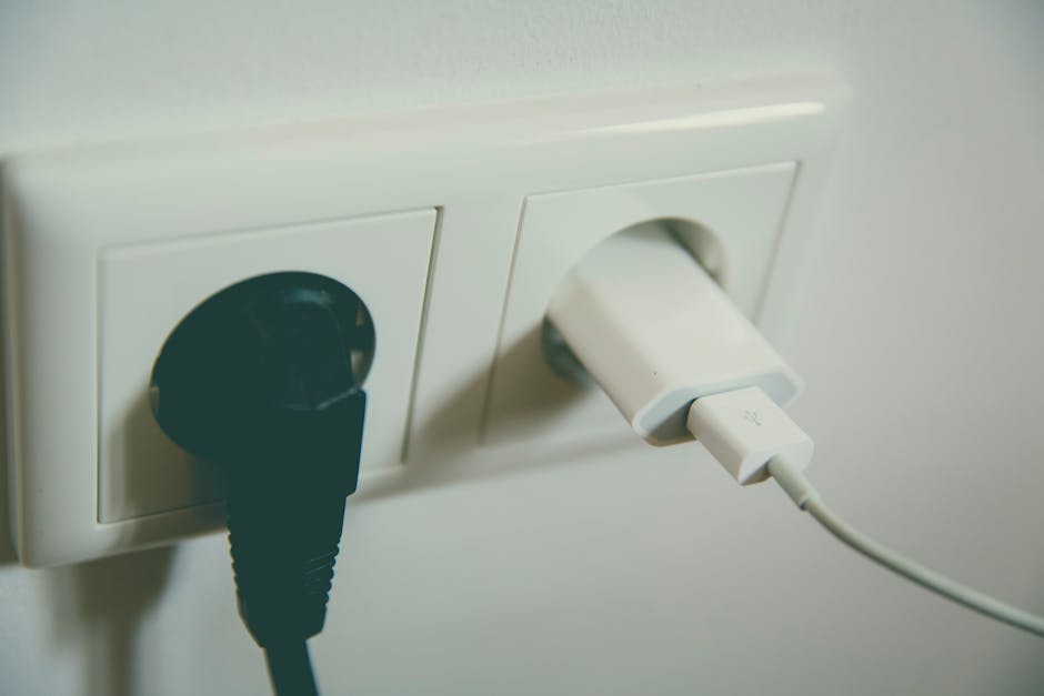 Šalia sieninio elektros lizdo matyti saugumo problemos požymiai ir kabelis